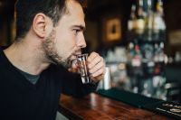Kaboompics - Handsome young man drinking vodka at the bar