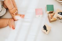 Detail of a newborn baby feet - wooden blocks - toys
