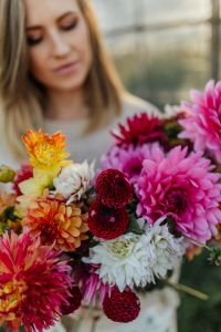 A woman with beautiful colorful dahlia flowers