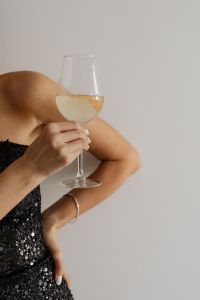Classy aesthetics - beautiful Asian woman in black evening dress - white wine in a glass