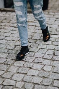 Woman in black sneakers and blue jeans