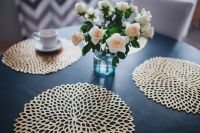 Kaboompics - Round breakfast table with golden coffee mats and white flowers