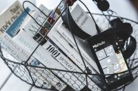 Kaboompics - Black smartphone and headphones and a basket of books