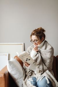 Kaboompics - Cocooning - isolating yourself - staying at home - a woman under a blanket - reading book