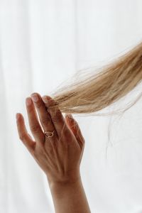 A hand holds a lock of hair