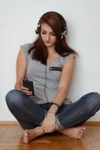 Kaboompics - Beautiful young woman in headphones listening to music