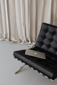 Laptop sits on a black leather chair - Barcel
