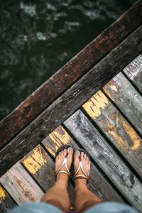 Detail of the legs of a woman standing at the edge of the pier