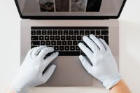 Kaboompics - Hands in hygienic glove typing on laptop