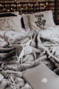 Drone, laptop and accessories lie on the bed ready for travel