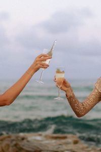 Kaboompics - Muted Tones & Golden Hour Hues - Women Celebrating by the Sea with Champagne