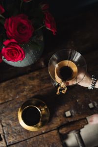 Enjoying a finely brewed coffee, gold coffee cup & red roses