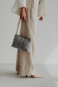 Anonymous female in trendy outfit with bag