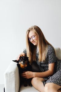 Kaboompics - A young girl sits on a chair with her small dog