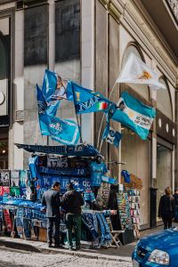 Stall with gadgets for fans of the football club SSC Napoli, blue flags and T-shirts