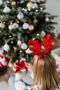 Kaboompics - Woman Wearing Reindeer Horns on Head, Wrapping Gift, Christmas Tree Background