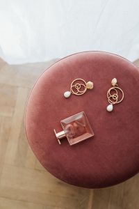 Jewellery & pink perfume on Pouf