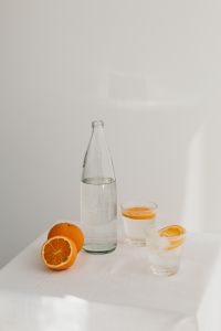 Fresh juicy oranges - a glass and a bottle of water
