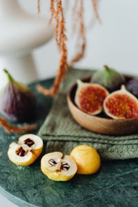 A wooden bowl containing fresh figs - Chaenomeles japonica