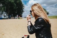 Kaboompics - Young woman smoking on the beach