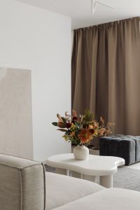 Minimalist living room with a vase of flowers on a white coffee table