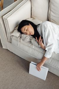 Young Asian woman relaxes on couch - sleeps on pillow