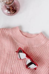 Flat lay collage - women's modern casual outfit, pink sweater, jeans, sunglasses