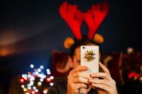 Kaboompics - A handsome man with Christmas presents takes pictures with his phone