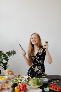 Teen Girl holding a knife and cucumber