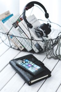 Black smartphone and headphones with various items