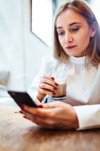 Woman in cafe using mobile phone