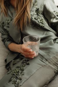 Kaboompics - Woman in Satin Ensemble with French Manicure Holding a Glass of Water