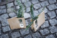 Miniature green plants in a small glass on cobblestone