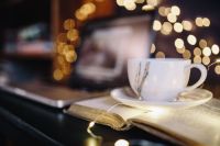 Cup of coffee, book, fairy lights
