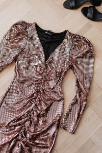 Kaboompics - gold rose sequin dresses and boots lie on a wooden parquet,