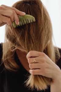 A woman combs her hair with a jade comb