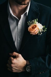 A man in a suit with flowers in a Boutonnière