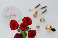 Kaboompics - Red roses, gold rings, perfume brushes and make-up accessories on white marble