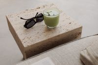 Kaboompics - Travertine Coffee Table with Matcha Latte and Sunglasses - Minimalist Interior