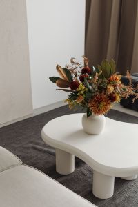 Minimalist living room with a vase of flowers on a white coffee table