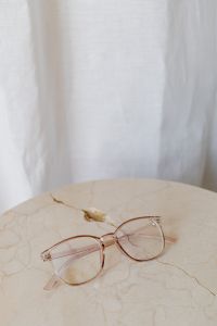Corrective glasses lie on a marble table