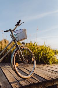 Bicycle with basket on the pier in bright sunset light