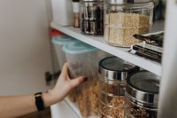 Containers of cereals in kitchen cupboard
