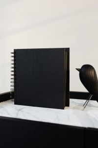 Kaboompics - blackbook & wooden bird on marble