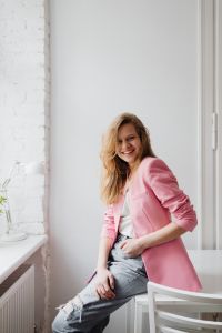 Beautiful teenage girl with long blonde hair wearing a pink jacket