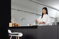 Kaboompics - An adult young Asian woman pours coffee into a cup from a Chemex