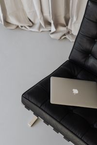 Laptop sits on a black leather chair - Barcel