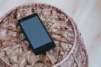 Kaboompics - Black smartphone on a miniature brown table