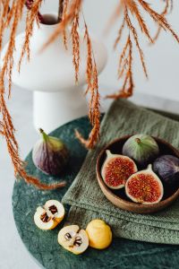A wooden bowl containing fresh figs - Chaenomeles japonica