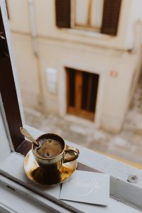 Kaboompics - Drink coffee in a golden cup at the window